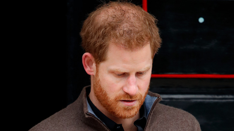 Prince Harry looks at the ground