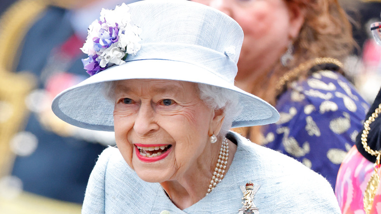 Queen Elizabeth wearing three-strand pearls and broach