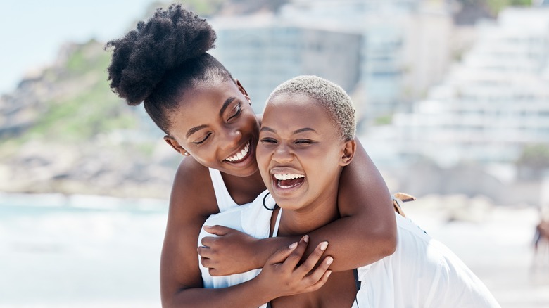 smiling women walking on beach