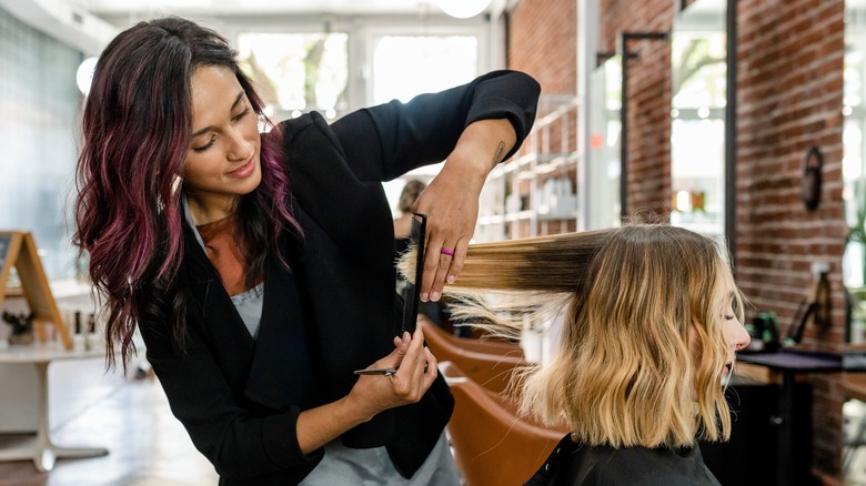 Woman getting hair trim at salon