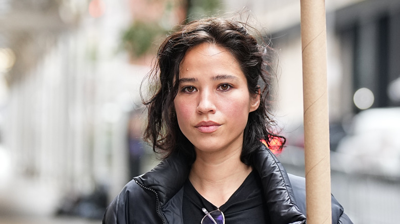 Kelsey Asbille smirking with a sign