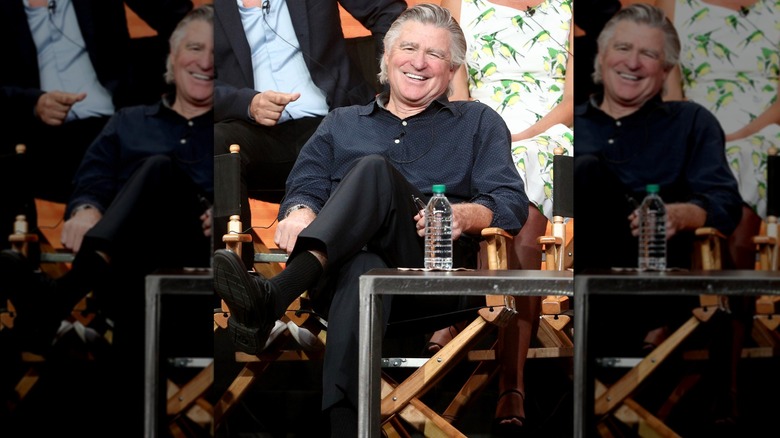 Treat Williams in director's chair smiling