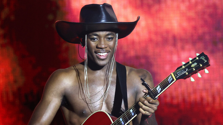 David Banda playing the guitar topless in cowboy hat