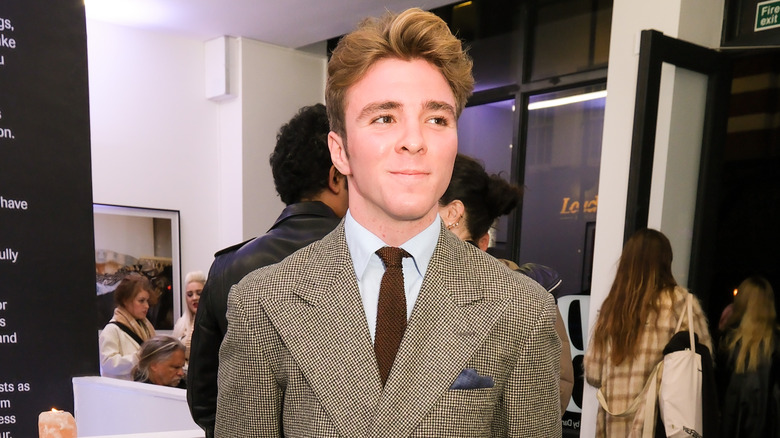 Rocco Ritchie smiling in art gallery wearing suit