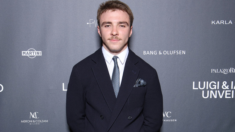 Rocco Ritchie posing in suit on step-and-repeat