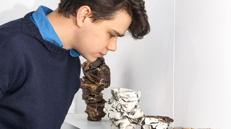 Samuel Chatto looks down at his pottery works at an art gallery