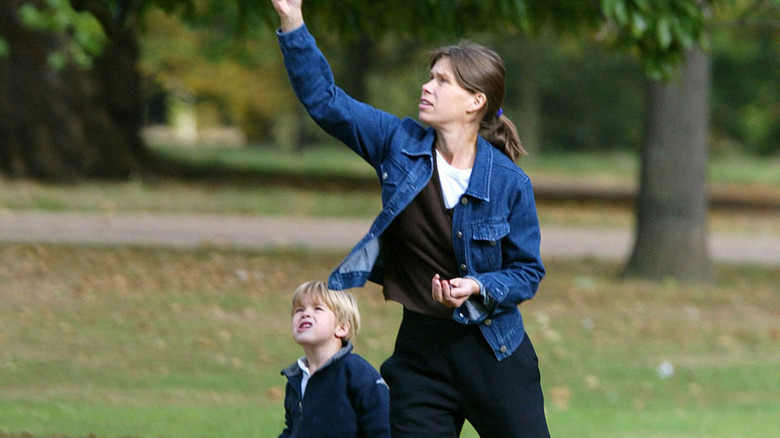 A young Sam Chatto walks with his mom chasing a kite in a park