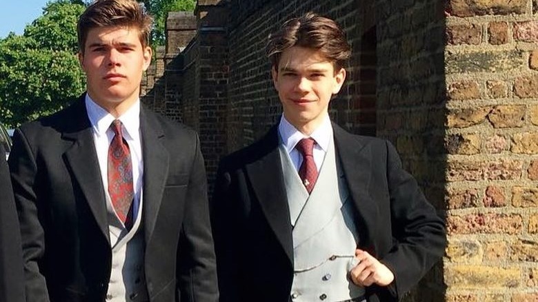 Samuel Chatto stands next to this brother Arthur in matching three piece suits in front of a brick wall at Meghan and Harry's wedding.