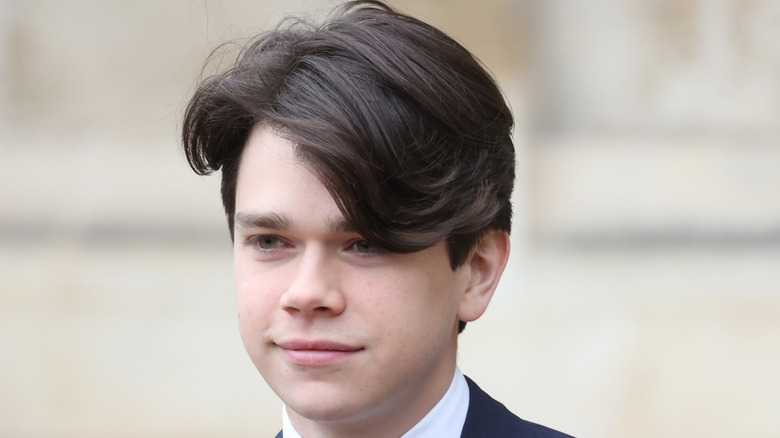 Sam Chatto smiles looking in the distance in a close up photo of him in a suit.