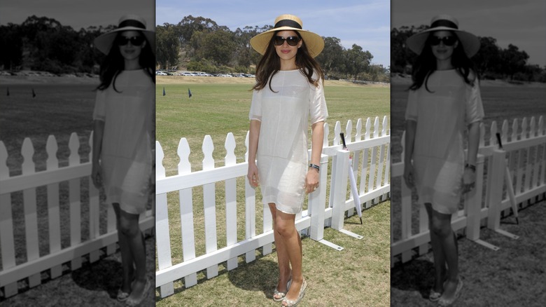 Sophie Winkleman smiling beside a white picket fence in Los Angeles