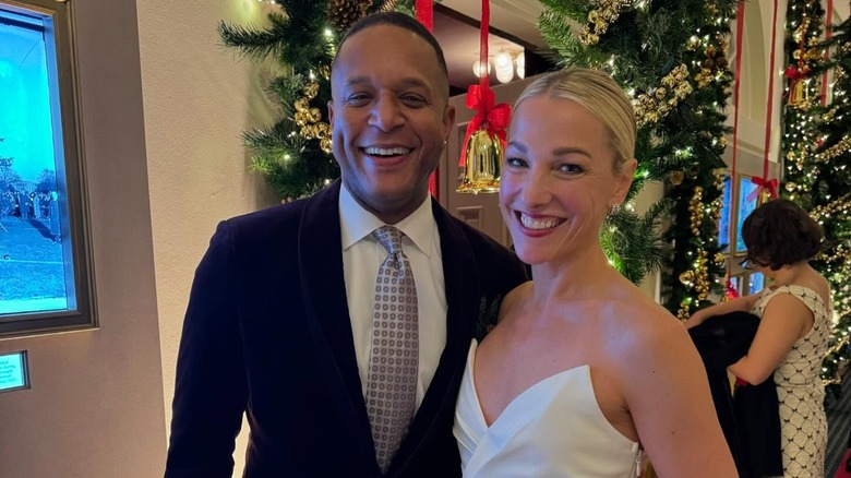 Craig Melvin and his wife Lindsay smile inside of the White House in front of holiday decor