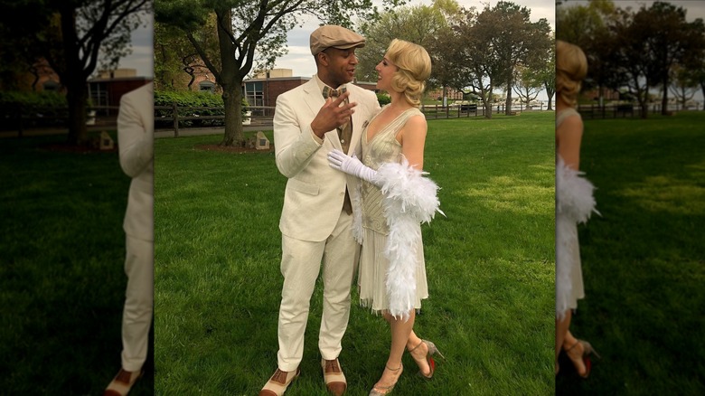 Craig Melvin and his wife Lindsay look at each other dressed in 1920s attire outside