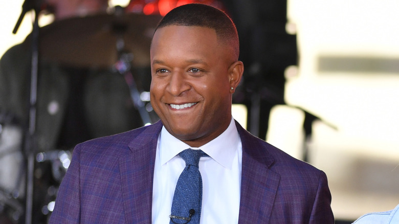 Craig Melvin smiling in purple suit