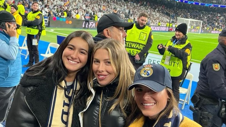 Hannah Selleck standing on the sidelines of a Real Madrid game with two friends