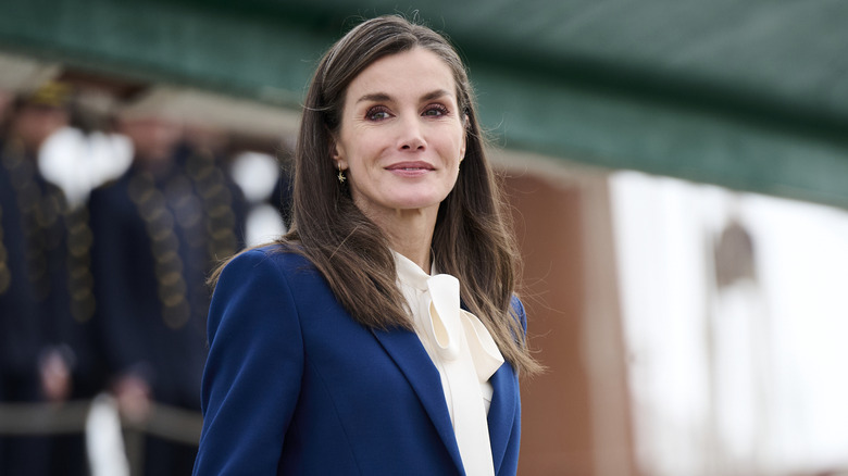 Queen Letizia outside in blue blazer and white pussybow blouse