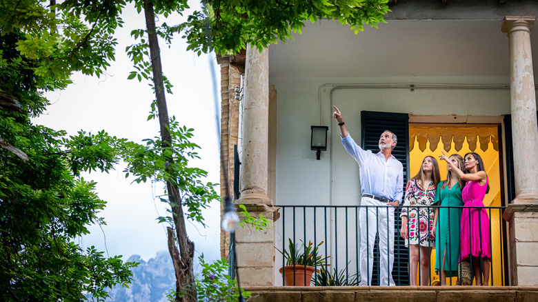 Queen Letizia and King Felipe on balcony with their daughters pointing up at tree