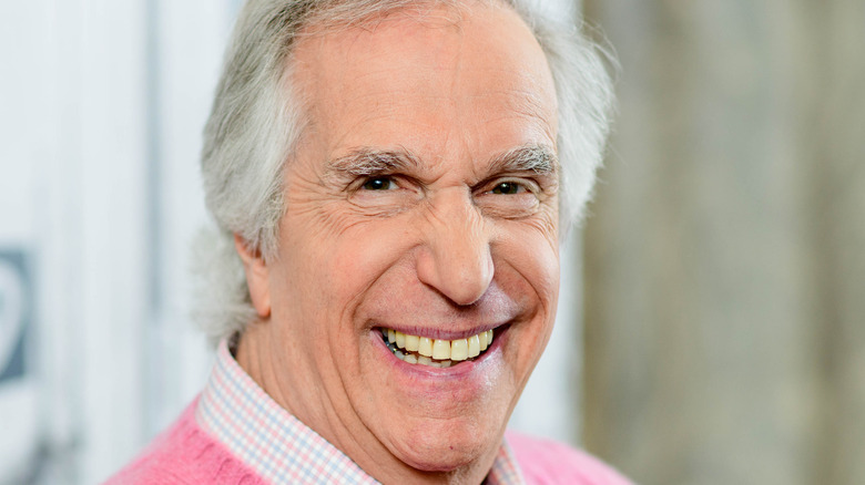 Henry Winkler smiling in a pink jumper