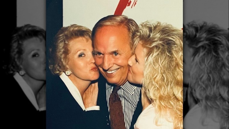 William J. Bell smiling while wife and daughter kiss his cheeks