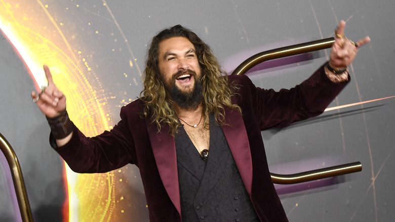 Jason Momoa doing devil horns on the red carpet