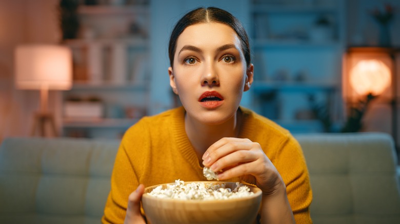 Woman eating popcorn watching movie