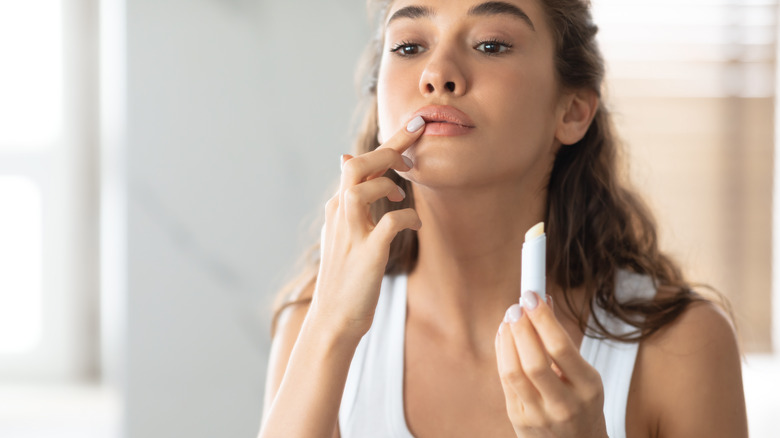 woman applying lip balm