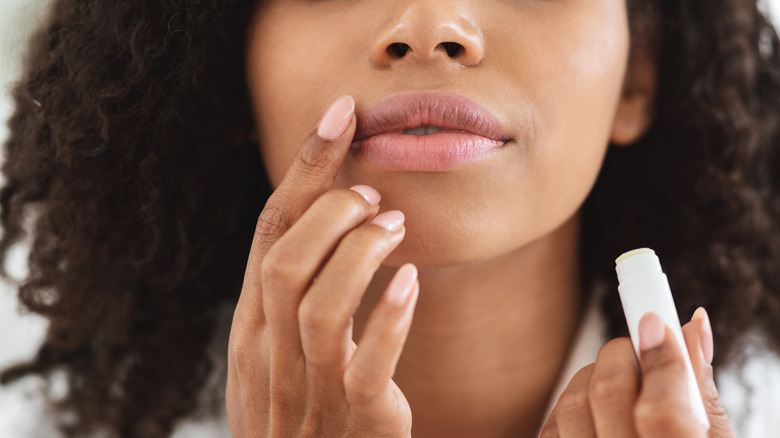 woman applying lip balm