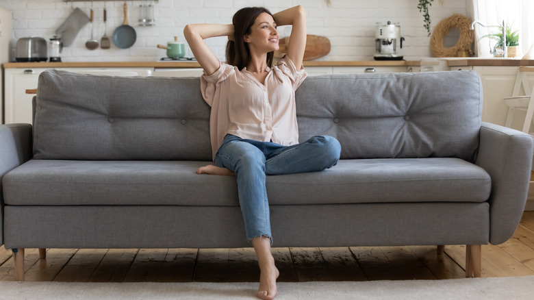 Woman sits back on a couch