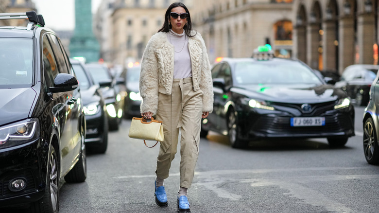 women walks street in trendy outfit