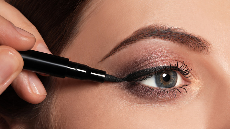 close up of woman applying liquid eyeliner