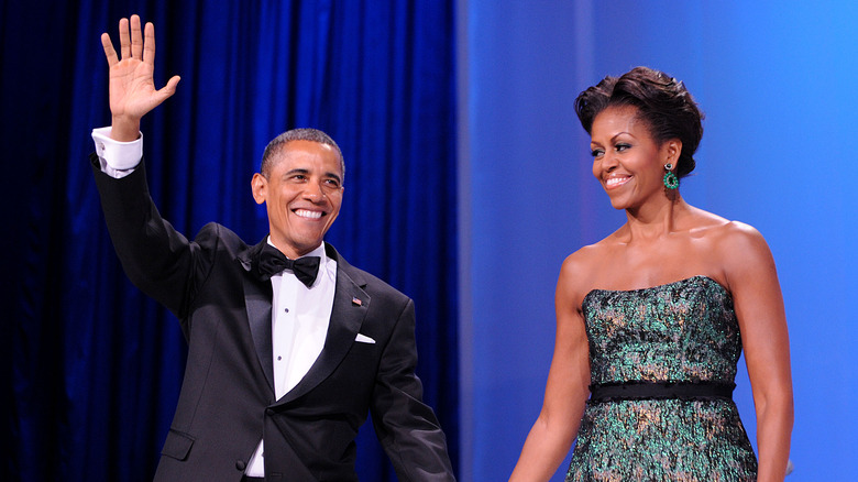 Barack Obama smiling and waving with Michelle Obama