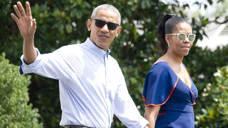 Barack Obama waving with Michelle on walk