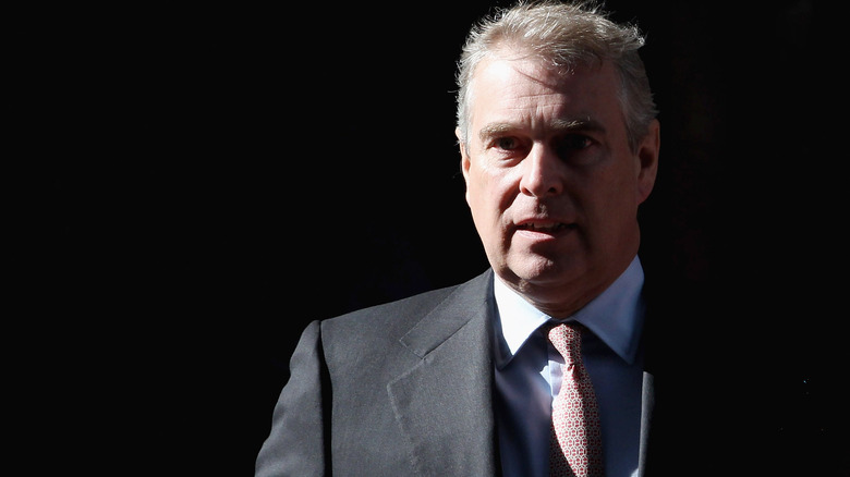 Prince Andrew looking serious with his face half in shadow