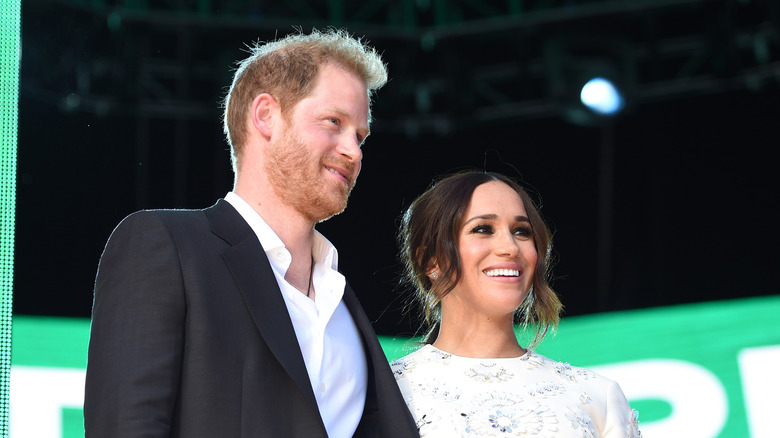 Prince Harry and Meghan Markle smiling in side profile