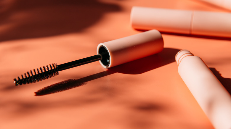 Mascara tube on orange background 