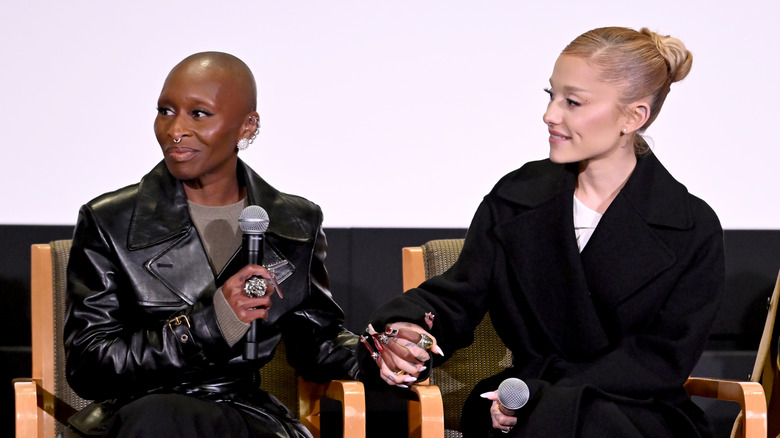 Ariana Grande and Cynthia Erivo holding hands while talking