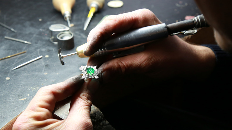 person holding a emerald ring