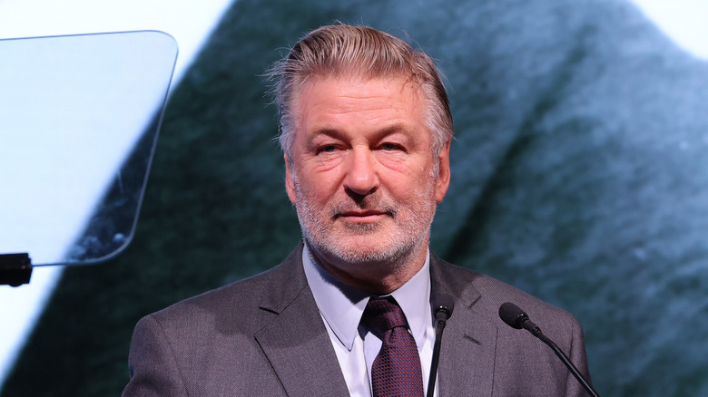 Alec Baldwin standing at a microphone