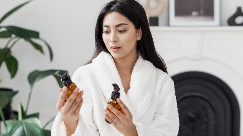 Woman evaluating two skincare products