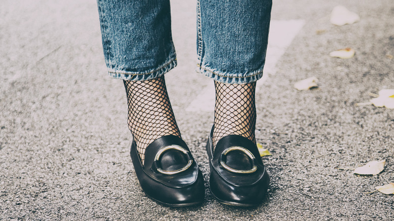 Woman wearing black loafers with fishnet socks 