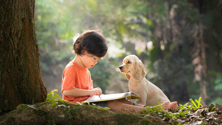 baby with book and puppy