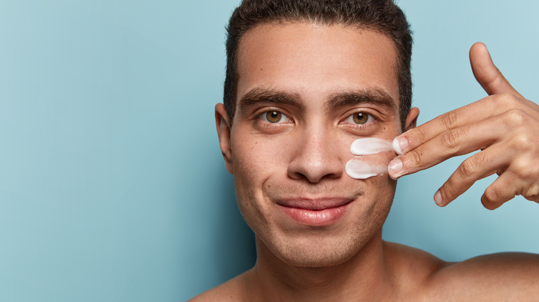 Man applying cream to healthy skin