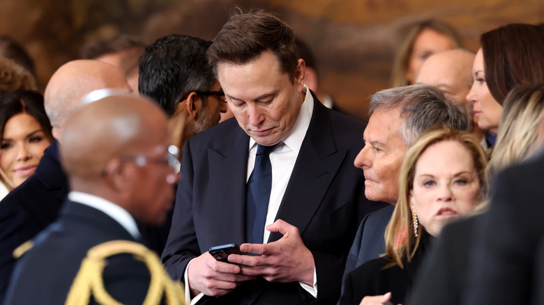 Elon Musk looking at his phone