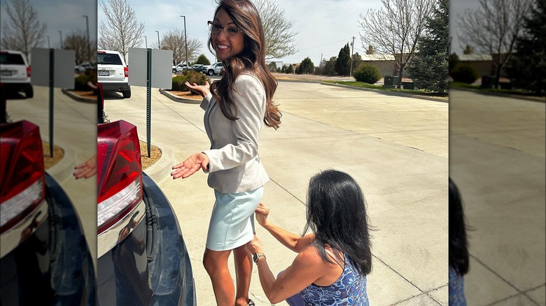 Lauren Boebert shrugs as a woman cleans her skirt