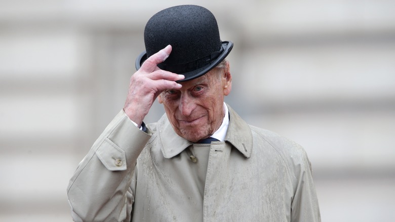 Prince Philip, who's had a royal family interview, in trench coat and hat