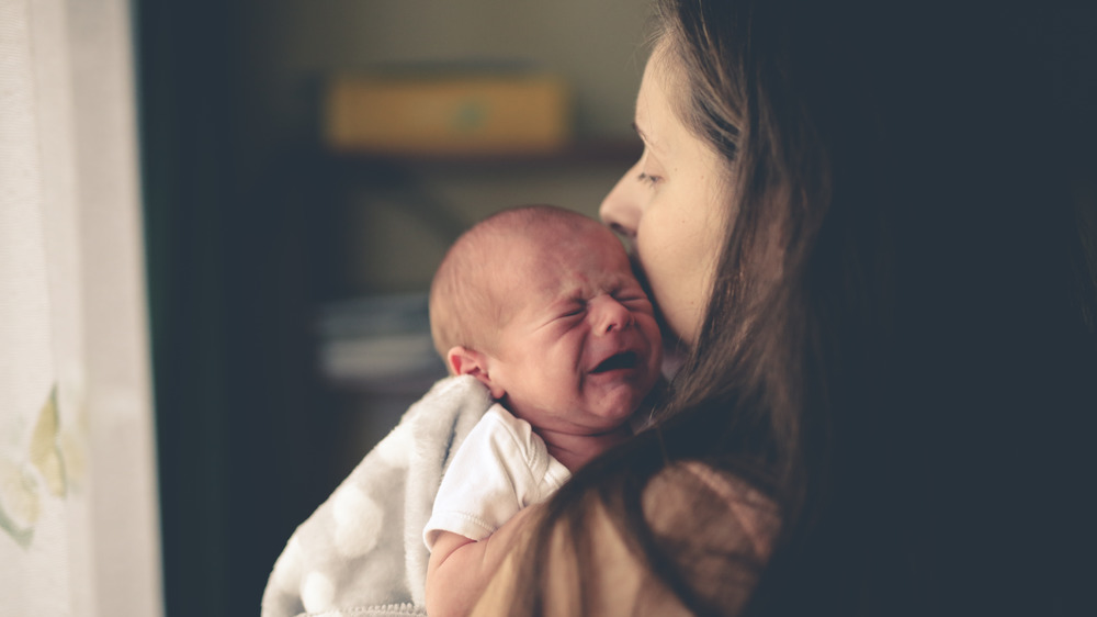 Mom comforting a crying newborn