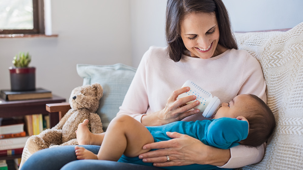 Woman feeding a baby a bottle of formula