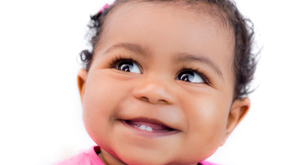 Baby smiling and showing first teeth