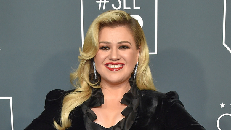 Kelly Clarkson smiling on red carpet in black dress