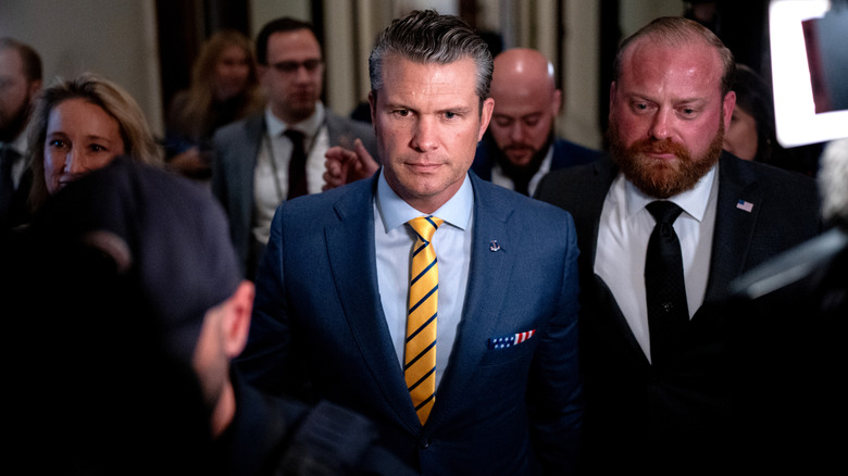 Pete Hegseth attending a press conference in a yellow tie