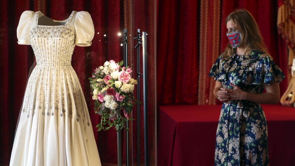 Princess Beatrice looking at her dress and bouquet